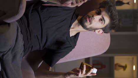 Vertical-video-of-Troubled-man-looking-at-knife-and-pills-in-front-of-him.